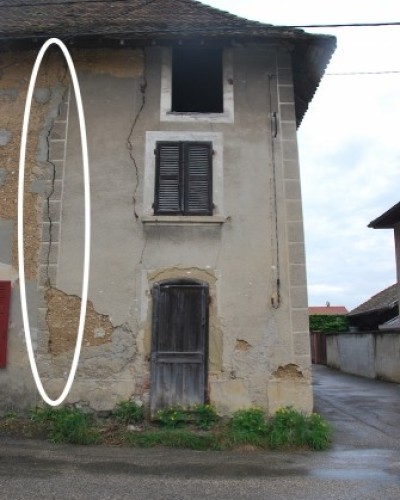 Fissure traversante d'un mur en pisé réparée entre voisins