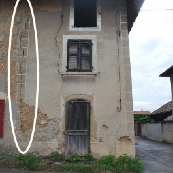 Fissure traversante d'un mur en pisé réparée entre voisins