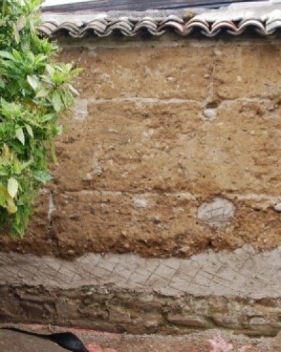 Réparation en famille d'un mur en pisé à Francheville